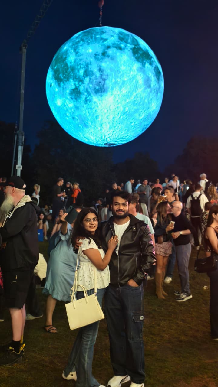 Ravi and Soumya under a giant moon installation at night