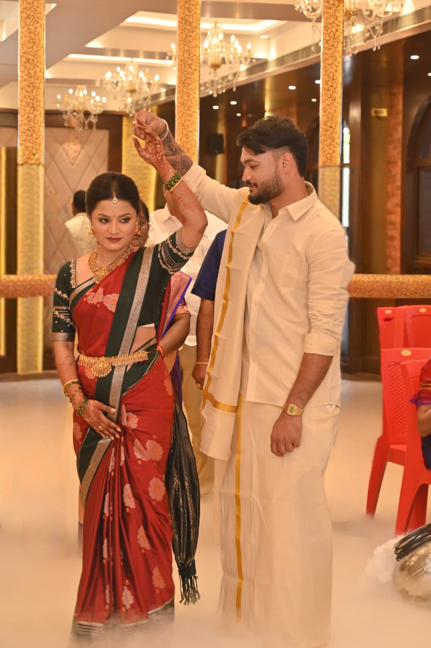 Ravi twirling Soumya in her red and green saree