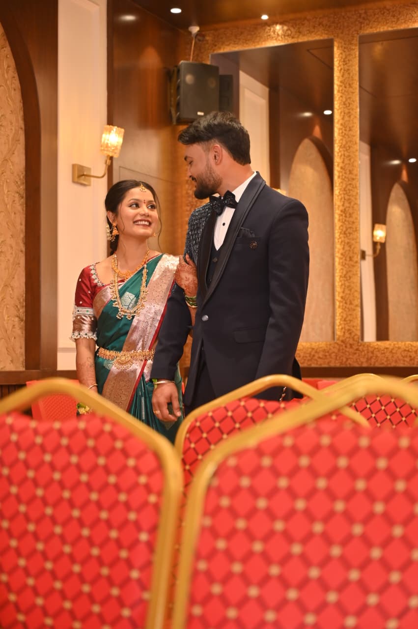 Ravi and Soumya among the hall's red chairs