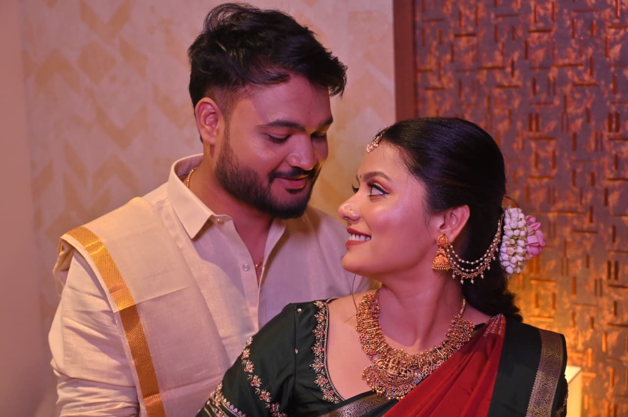Ravi and Soumya sharing a quiet smile, warm lights behind